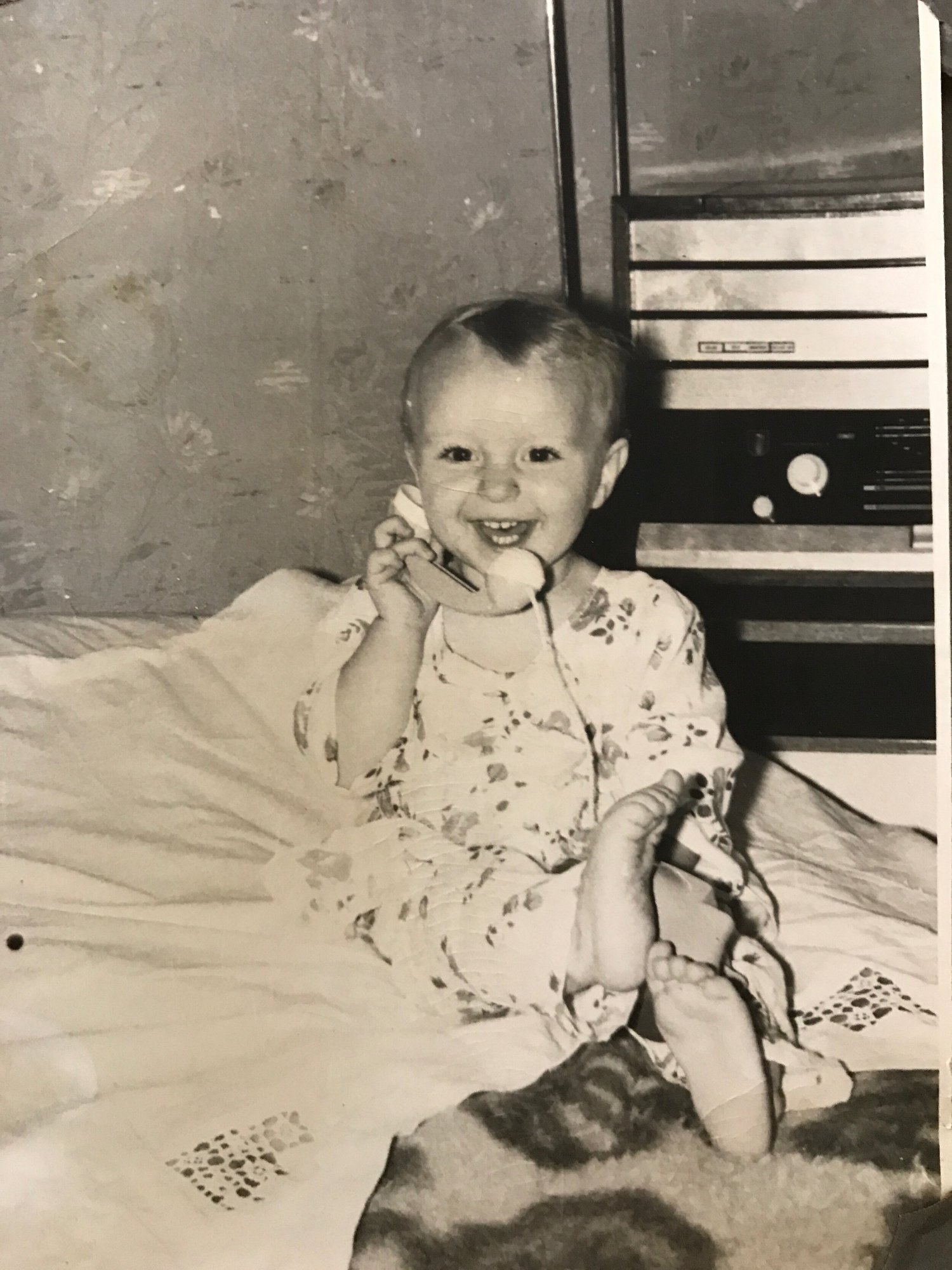 A smiling baby in a black-and-white family photograph